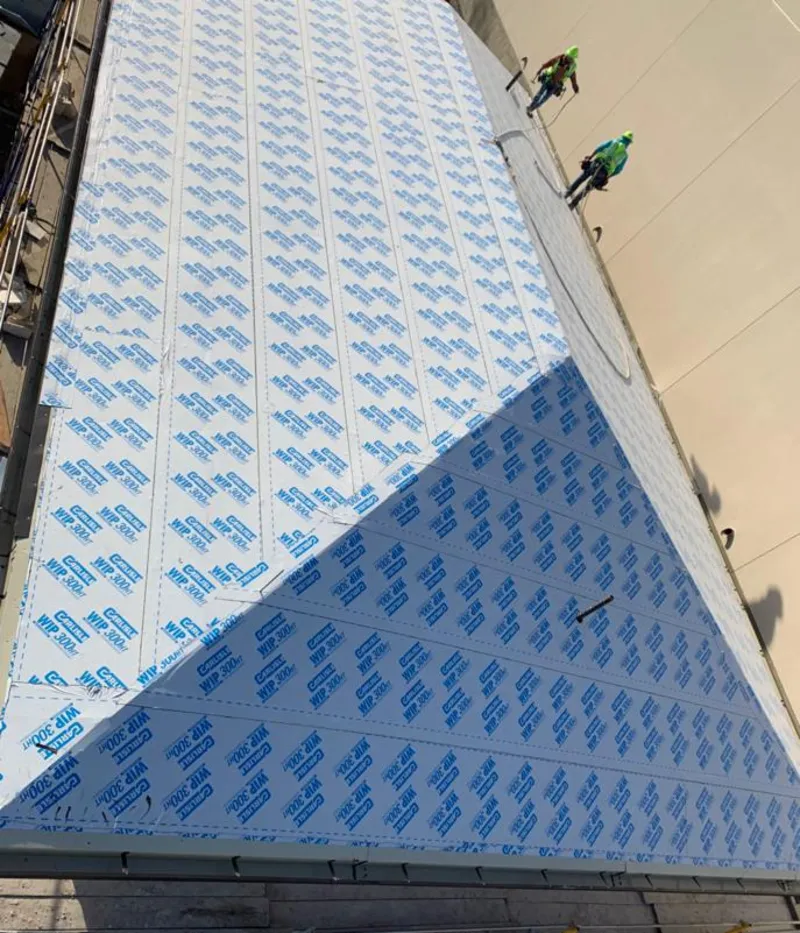 Professional roofers installing underlayment on a metal roof in Spanish Fork